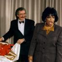 Artist Lawrence Romorini unveiling large shadow box collage for Oprah Winfrey, who is standing next to the art with jaw dropped