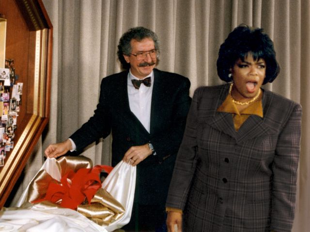 Artist Lawrence Romorini unveiling large shadow box collage for Oprah Winfrey, who is standing next to the art with jaw dropped