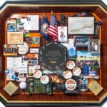 Large collage with over 50 items for the president and CEO of Exelis. Containing items and images that celebrate the company's history and honor the CEO's leadership and accomplishments.