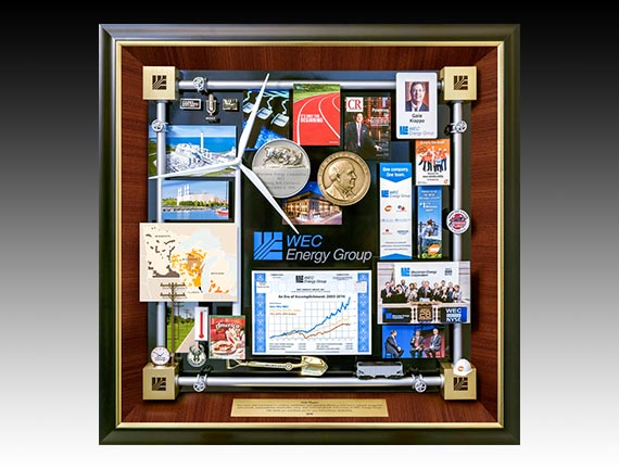 WEC Energy Retirement Gift presented to CEO as gift of appreciation. Features miniature windmill, medallion, ID card, growth chart, miniature hard hat. The border is created with miniature energy pipes.
