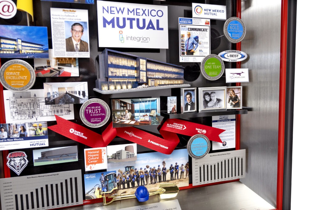 3-dimensional collage gifted to retiring President and CEO. Includes miniaturized photos, publications, and graphs showcasing the company's growth. 