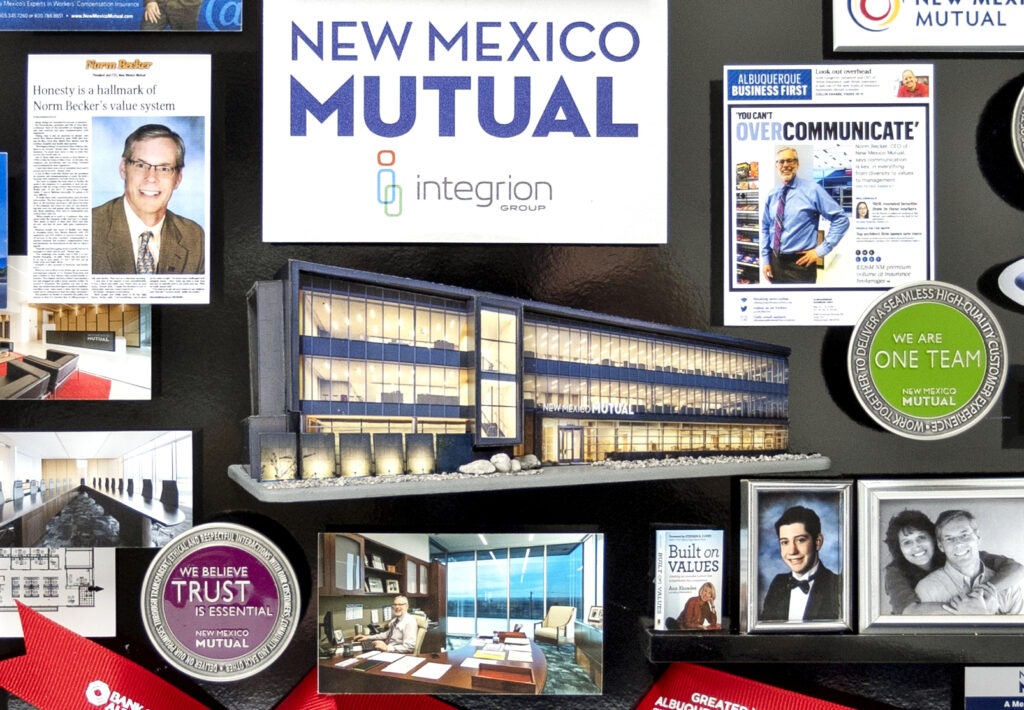 3-dimensional collage containing miniaturized items includes 3D replica of New Mexico Mutual headquarters building. 