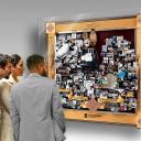 People looking at large shadow box collage commemorating Inova Alexandria Hospital's 125-year retrospective