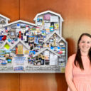 NVAR staff and the artist standing next to anniversary collage in lobby